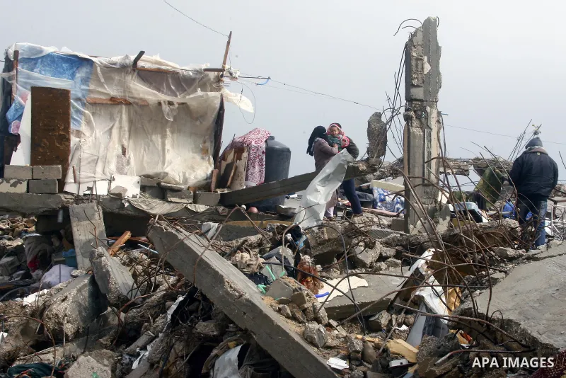 A Palestinian woman, stands on the rubbles of her house, which was destroyed by Israeli shelling during a 50- day-war last summer, on a stormy day in the east of Khan Younis in the southern Gaza Strip January 8, 2015. He...