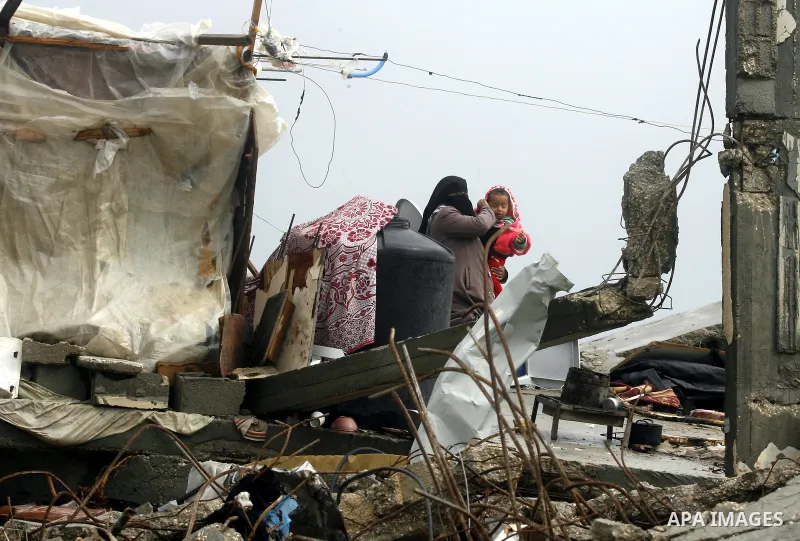 A Palestinian woman, stands on the rubbles of her house, which was destroyed by Israeli shelling during a 50- day-war last summer, on a stormy day in the east of Khan Younis in the southern Gaza Strip January 8, 2015. He...