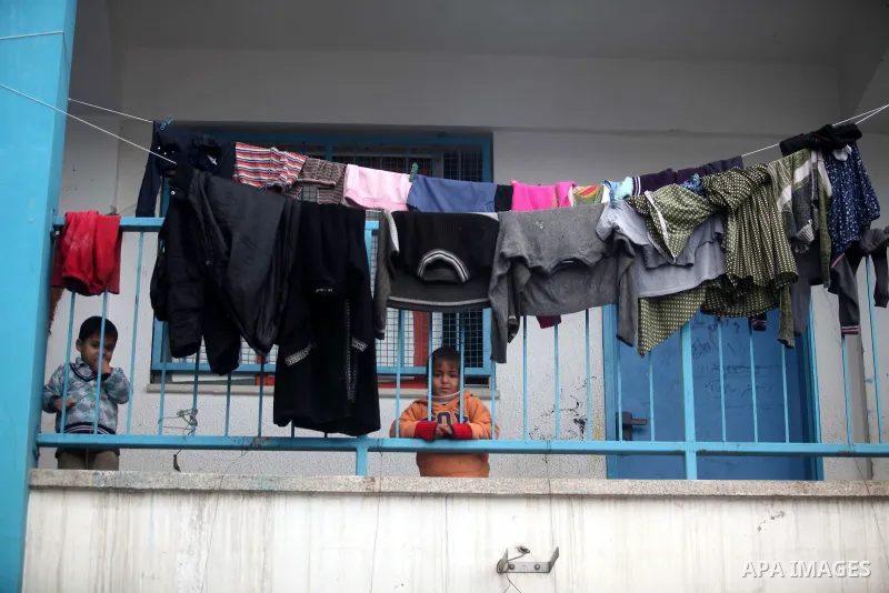 Palestinians children play at a United Nations (UN) run school sheltering Palestinians, whose houses were destroyed in the 50- day-war Israeli last summer, during a winter storm in Beit Hanoun in the northern Gaza Strip...