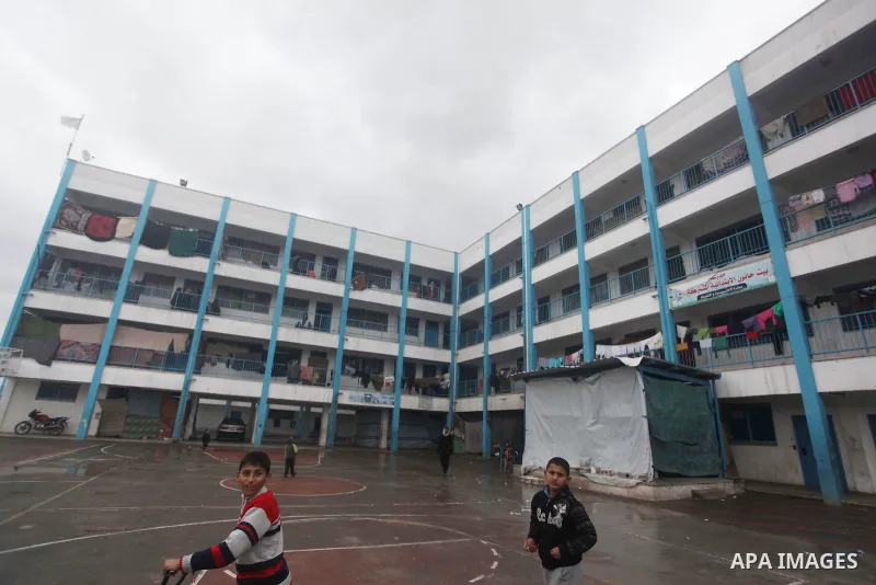 Palestinians children play at a United Nations (UN) run school sheltering Palestinians, whose houses were destroyed in the 50- day-war Israeli last summer, during a winter storm in Beit Hanoun in the northern Gaza Strip...