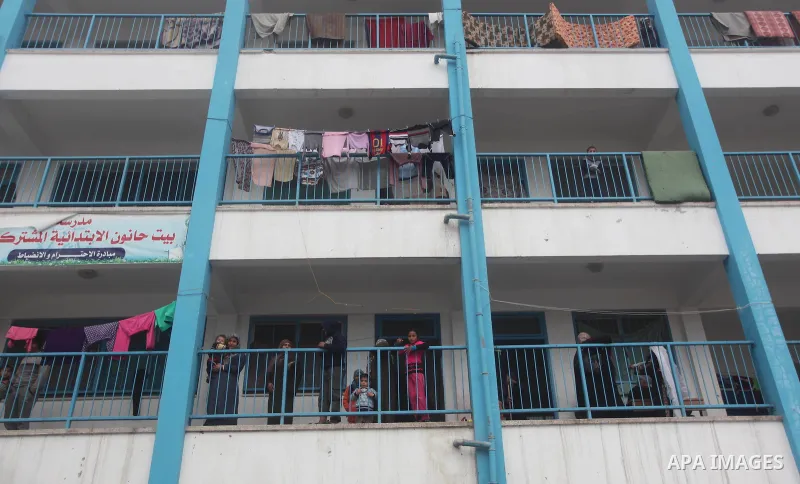 Palestinians stand outside classrooms at a United Nations (UN) run school sheltering Palestinians, whose houses were destroyed in the 50- day-war Israeli last summer, during a winter storm in Beit Hanoun in the northern...