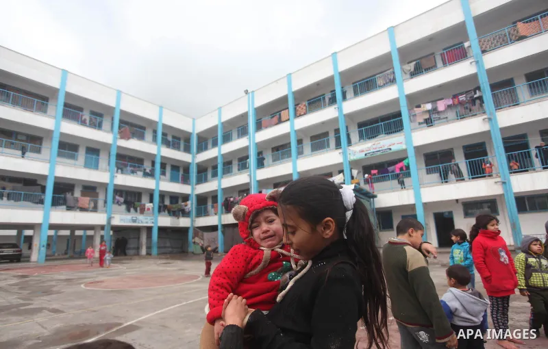 Palestinians children play at a United Nations (UN) run school sheltering Palestinians, whose houses were destroyed in the 50- day-war Israeli last summer, during a winter storm in Beit Hanoun in the northern Gaza Strip...