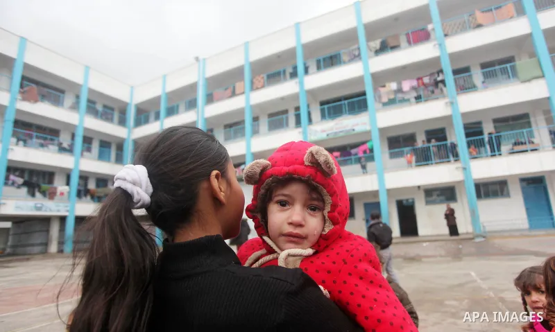 Palestinians children play at a United Nations (UN) run school sheltering Palestinians, whose houses were destroyed in the 50- day-war Israeli last summer, during a winter storm in Beit Hanoun in the northern Gaza Strip...