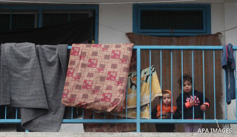 Palestinians children play at a United Nations (UN) run school sheltering Palestinians, whose houses were destroyed in the 50- day-war Israeli last summer, during a winter storm in Beit Hanoun in the northern Gaza Strip...