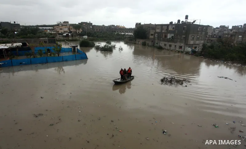 Members of Palestinian Civil Defence ride a boat as they evacuate people following heavy rain that flooded their houses in Rafah in the southern Gaza Strip January 9, 2015. Heavy rains and near-freezing temperatures in t...