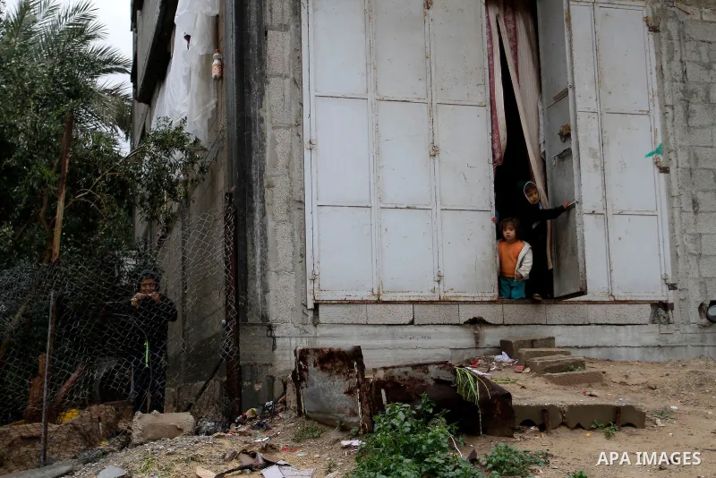 Palestinians look out of their house during heavy rain in Rafah in the southern Gaza Strip January 9, 2015. Heavy rains and near-freezing temperatures in the approaching storm threatened to deepen the misery in the Gaza...