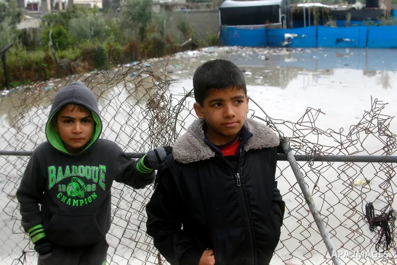 A Palestinian boys stand their his family's house following heavy rain in Rafah in the southern Gaza Strip January 9, 2015. Heavy rains and near-freezing temperatures in the approaching storm threatened to deepen the mis...