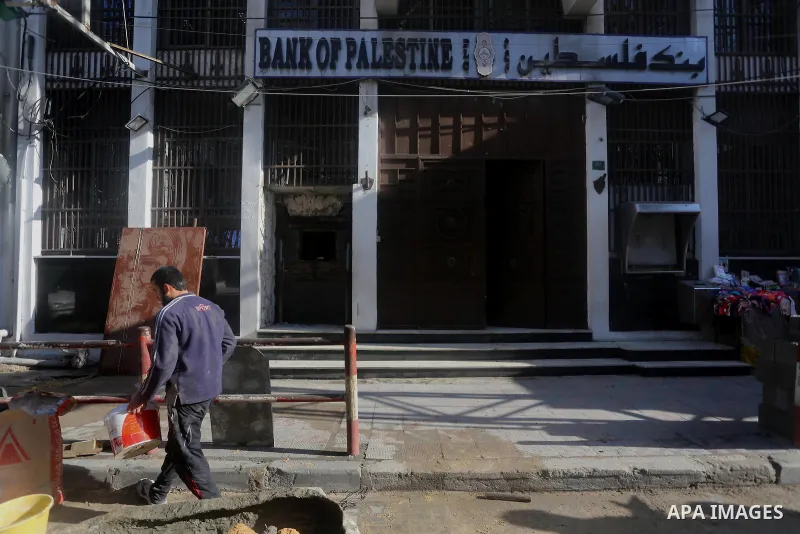 A Palestinian worker repairs a Palestine Bank following an explosion by unknown, in Gaza city January 10, 2014. The explosion of unknown origin damaged two ATM. Photo by Mohammed Asad