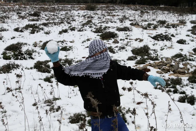 Palestinian children enjoy playing with the snow in the West Bank city of Nablus during snowy weather on 10 January 2015. A storm buffeted the Middle East with blizzards, rain and strong winds on Wednesday, keeping peopl...