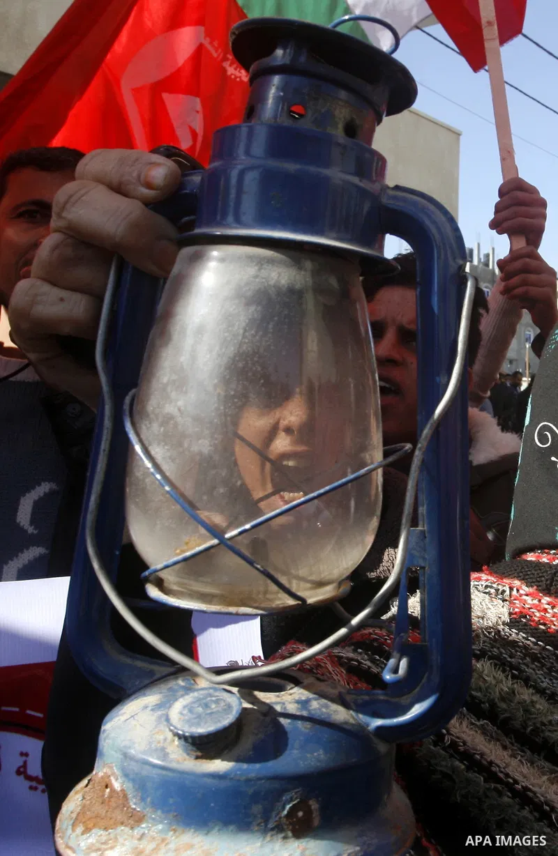 A Palestinian woman holds a kerosene lamp during a protest against power crisis in Gaza, in Rafah in the southern Gaza Strip January 12, 2015. The protest was organized by Palestinian leftist parties. Palestinian Energy...