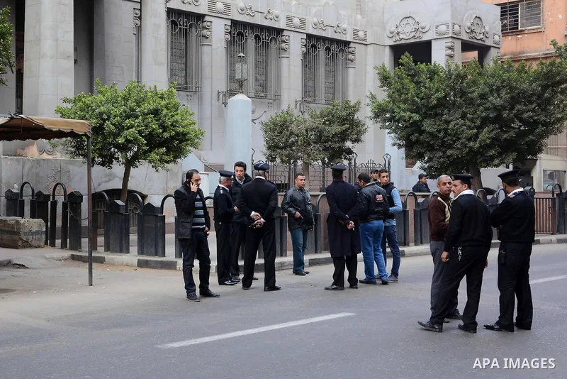 Egyptian policemen stand guard at the scene as an explosive expert tries to dismantle a homemade bomb in front of a Synagogue in Cairo on January 12, 2015. Egypt has seen a wave of bombings and shootings, mainly against...
