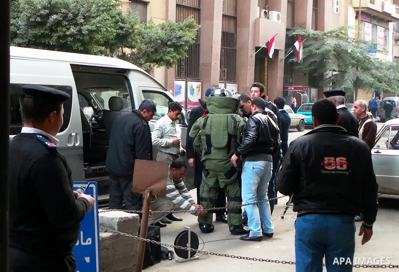 Egyptian policemen prepare an explosive expert to dismantle a homemade bomb in front of a Synagogue in Cairo on January 12, 2015. Egypt has seen a wave of bombings and shootings, mainly against army and police personnel,...