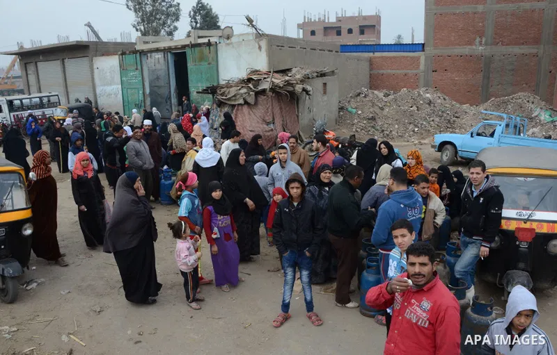 Egyptians stand in front of a gas canister warehouse, in Imbaba neighborhood, near Cairo, January 13, 2015. Long queues have been reported in recent days at depots across the country where cooking gas cylinders are sold,...