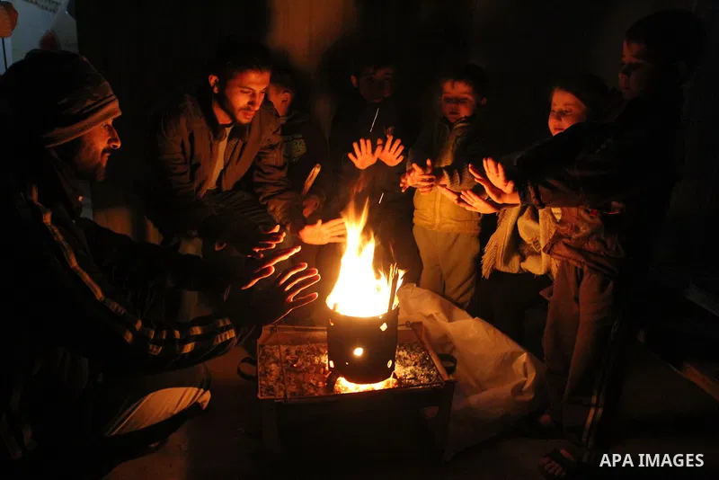 Palestinians warm themselves around a fire in Rafah in the southern Gaza Strip, January 14, 2014. The World Bank reported that 10% of Gaza's residents remain without electricity since the attack and the rest of the popul...