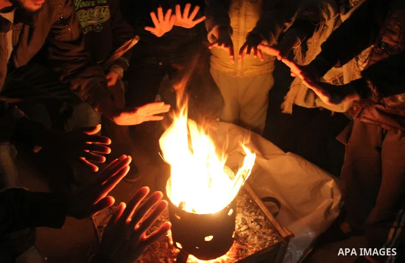 Palestinians warm themselves around a fire in Rafah in the southern Gaza Strip, January 14, 2014. The World Bank reported that 10% of Gaza's residents remain without electricity since the attack and the rest of the popul...