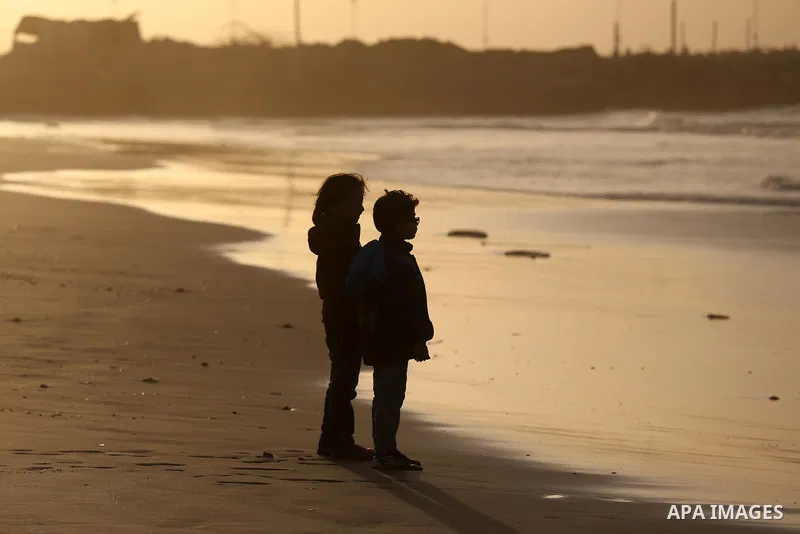 Palestinian children walk during the sunset at the beach of Gaza city, January 15, 2015. Photo by Yasser Qudih