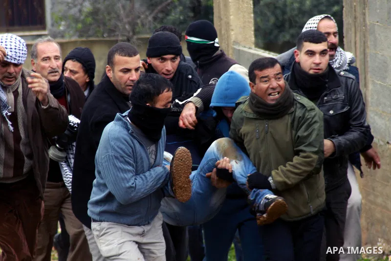 Palestinians carry a wounded fellow during clashes with Israeli security forces following a protest against the expropriation of Palestinian land by Israel in the village of Kafr Qaddum, near the West Bank city of Nablus...