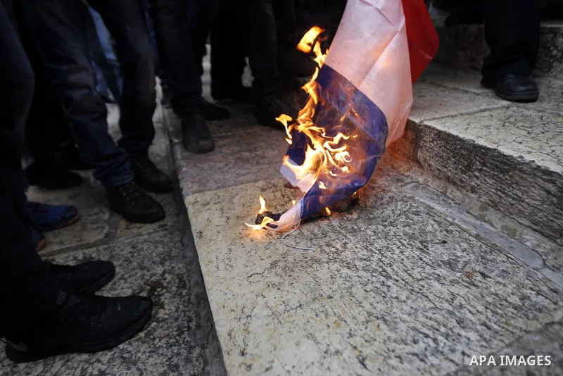 Palestinian protesters burn the French flag in front of the Dome of the Rock during a demonstration against the printing of satirical sketches of the Prophet Mohammed by French magazine Charlie Hebdo, on the compound kno...