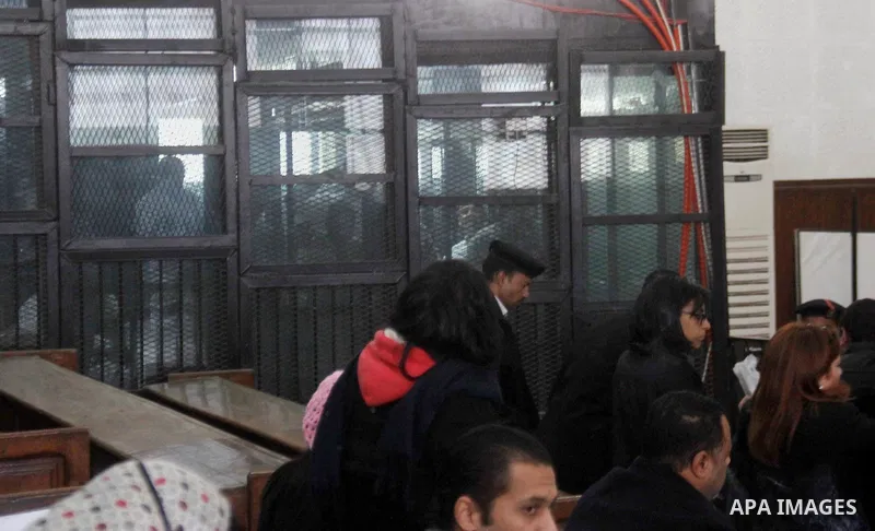 Defendants are seen behind bars during the retrial of Alaa Abdel Fattah and 24 others, in the courtroom in Cairo on January 17, 2015. The defendants were sentenced in June to 15 years in prison for holding an unlicensed...