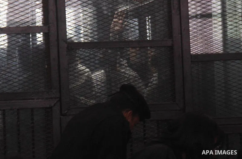 Defendants are seen behind bars during the retrial of Alaa Abdel Fattah and 24 others, in the courtroom in Cairo on January 17, 2015. The defendants were sentenced in June to 15 years in prison for holding an unlicensed...