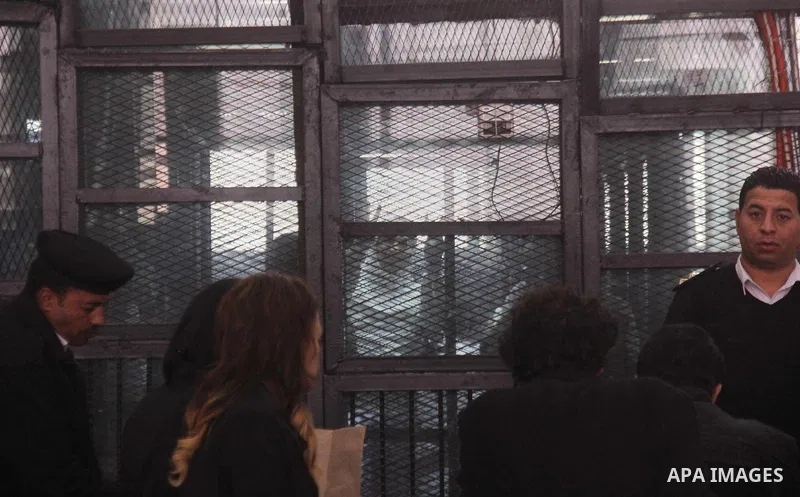 Defendants are seen behind bars during the retrial of Alaa Abdel Fattah and 24 others, in the courtroom in Cairo on January 17, 2015. The defendants were sentenced in June to 15 years in prison for holding an unlicensed...