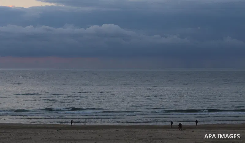 Palestinians walk during sunset at the beach of Gaza city on January 17, 2015. Photo by Mohammed Asad
