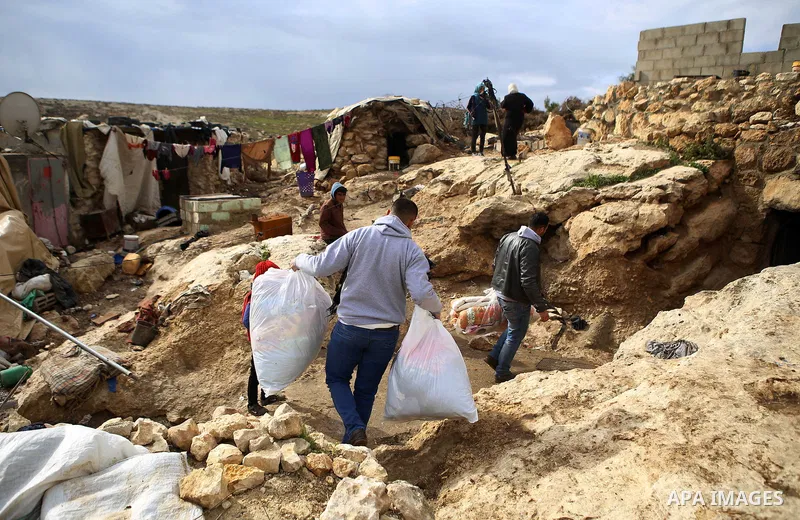 Palestinians provide charity to the Bedouins of Susia, south of the West Bank city of Hebron on January 17, 2015. Photo by Shadi Hatem