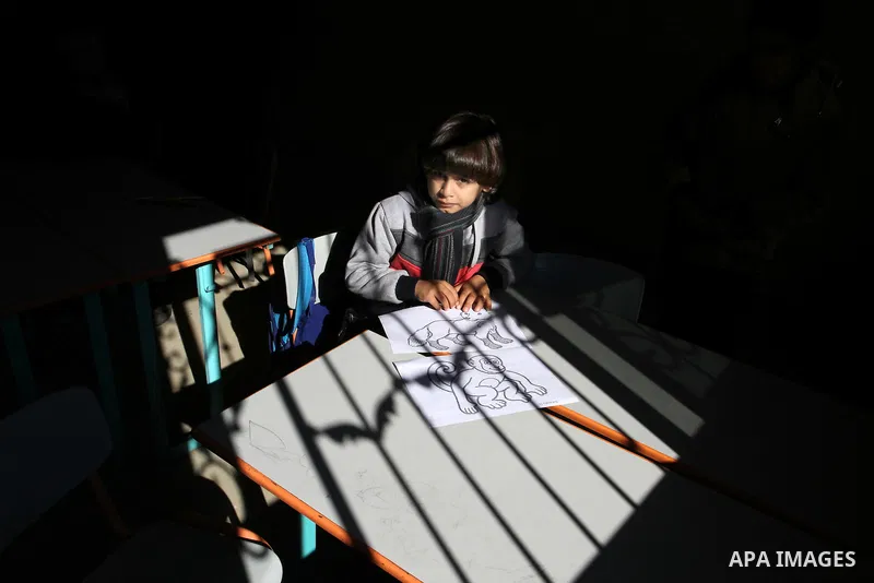 A deaf Palestinian boy colors a paint in a foundation for rehabilitation deaf children, in Khan Younis in the southern Gaza Strip, January 18, 2015. There are approximately 25,000 deaf and hearing impaired people in the...