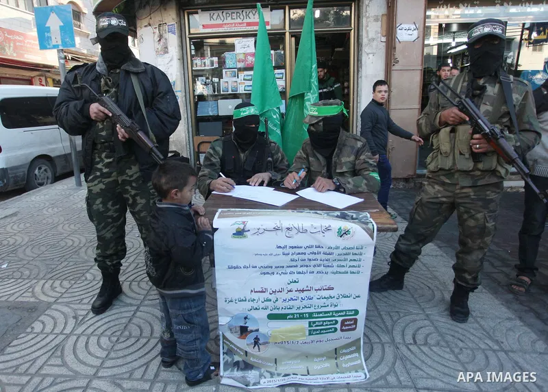 Palestinian members of Ezzedin al-Qassam brigades, the armed wing of Hamas movement, sit in a street to register young Palestinians for a winter military-style camp, in Gaza city on January 18, 2015. Hamas recently forme...