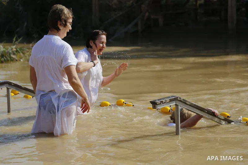 Christian pilgrims dip in the water after a ceremony at the baptismal site known as Qasr el-Yahud on the banks of the Jordan River near the West Bank city of Jericho January 18, 2015. Orthodox Christians flocked to the J...
