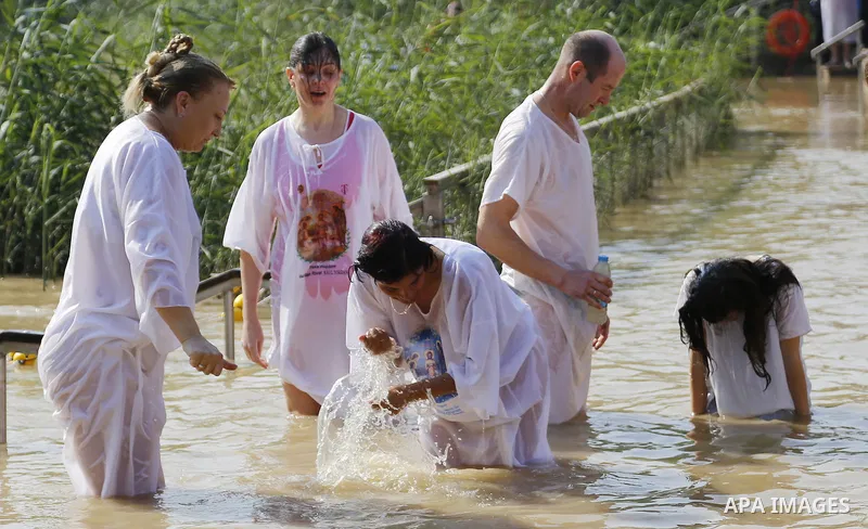 Christian pilgrims dip in the water after a ceremony at the baptismal site known as Qasr el-Yahud on the banks of the Jordan River near the West Bank city of Jericho January 18, 2015. Orthodox Christians flocked to the J...