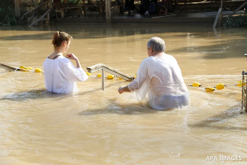 Christian pilgrims dip in the water after a ceremony at the baptismal site known as Qasr el-Yahud on the banks of the Jordan River near the West Bank city of Jericho January 18, 2015. Orthodox Christians flocked to the J...