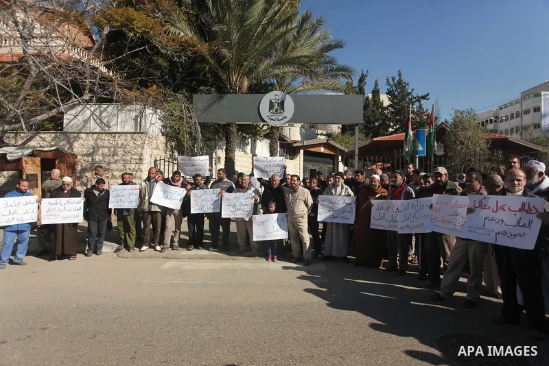 Palestinians take part in a protest organized by employees of former Palestinian government demanding their salaries to be paid, in front of the headquarters of the Council of Ministers in Gaza city on January 20, 2015....