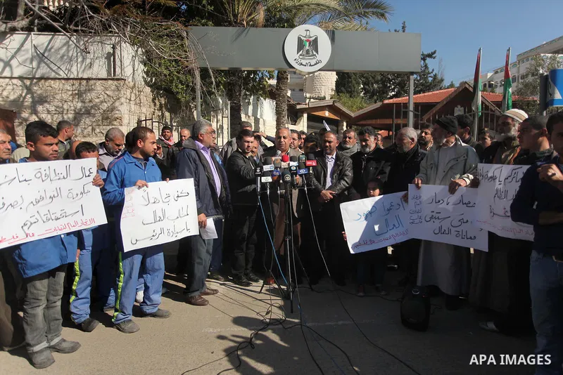 Palestinians take part in a protest organized by employees of former Palestinian government demanding their salaries to be paid, in front of the headquarters of the Council of Ministers in Gaza city on January 20, 2015....