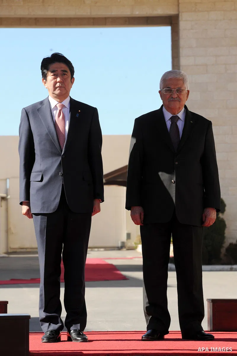 Japan's Prime Minister Shinzo Abe (L) and Palestinian President Mahmoud Abbas review the honor guard upon Abe's arrival to the West Bank city of Ramallah January 20, 2015. Abe demanded in a press conference in Jerusalem...