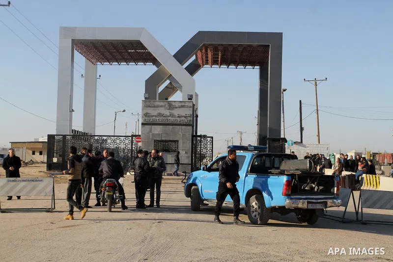Member of Palestinian security forces loyal to Hamas stand guard as people wait to ride in a bus to cross into Egypt at the Rafah crossing between Egypt and the southern Gaza Strip January 22, 2015. Egyptian authorities...