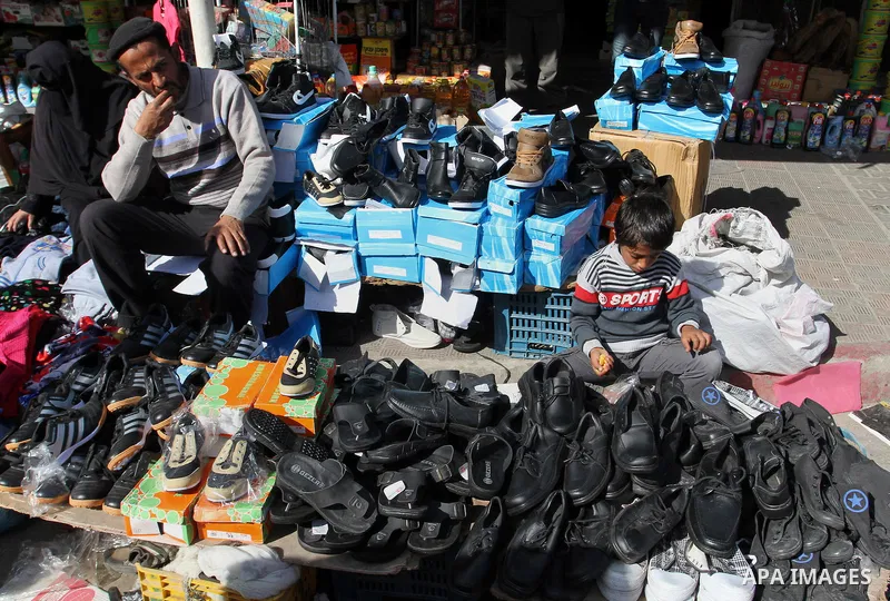 A Palestinian vendor displays the shoes at the main market in Rafah in the southern Gaza Strip on January 24, 2015. Photo by Abed Rahim Khatib