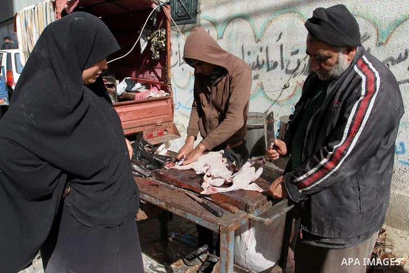 A Palestinian man cleans chicken meat at a poultry shop in Rafah in the southern Gaza Strip on January 24, 2015. Photo by Abed Rahim Khatib