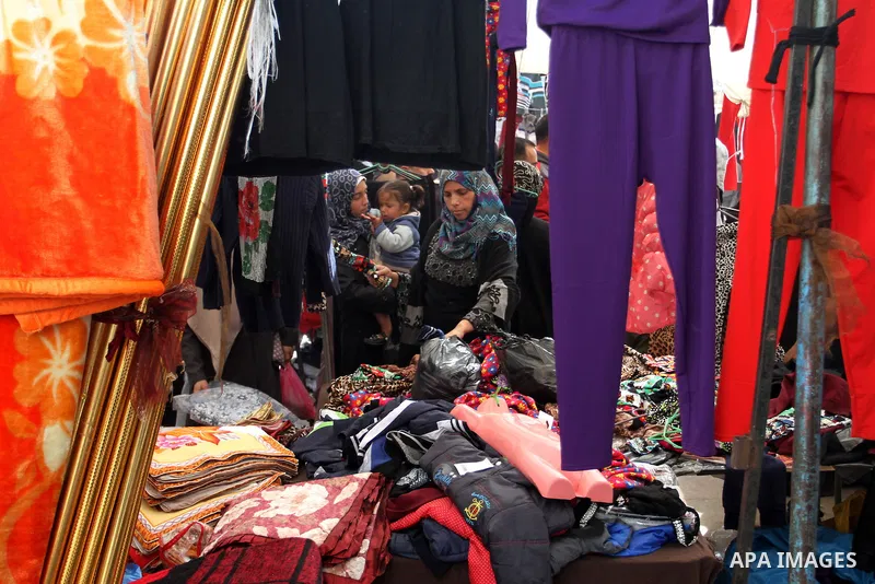 A Palestinian vendor displays the clothes at the main market in Rafah in the southern Gaza Strip on January 24, 2015. Photo by Abed Rahim Khatib