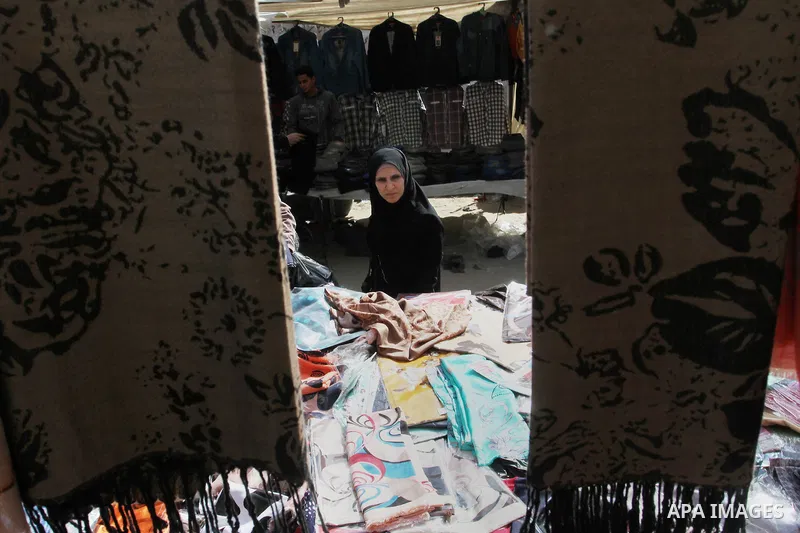A Palestinian vendor displays the clothes at the main market in Rafah in the southern Gaza Strip on January 24, 2015. Photo by Abed Rahim Khatib