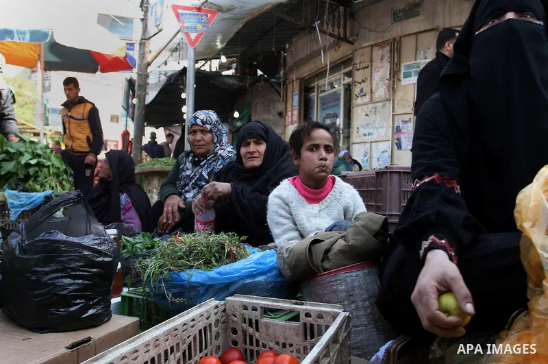 A Palestinian woman sells a vegetables at the main market in Rafah in the southern Gaza Strip on January 24, 2015. Photo by Abed Rahim Khatib