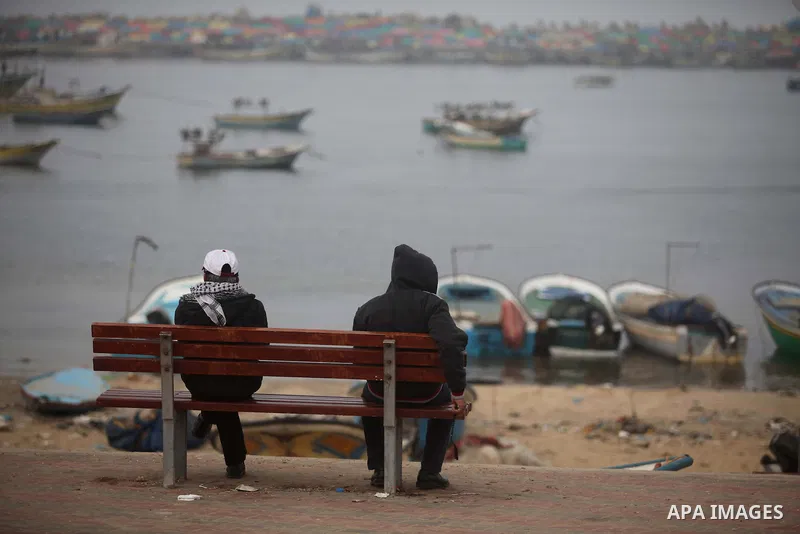 Palestinian men sit on a bench at the port of Gaza City on January 25, 2015. Israel's navy opened fire at fishing boats off the coast of the Gaza Strip on January 21, 2015 wounding two Palestinian fishermen, the Gaza hea...