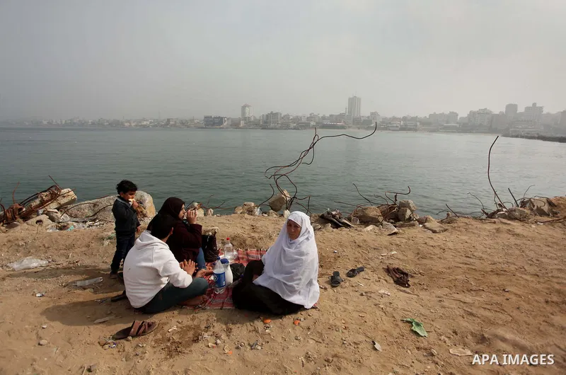 Palestinian family sit on at the port of Gaza City on January 25, 2015. Israel's navy opened fire at fishing boats off the coast of the Gaza Strip on January 21, 2015 wounding two Palestinian fishermen, the Gaza health m...