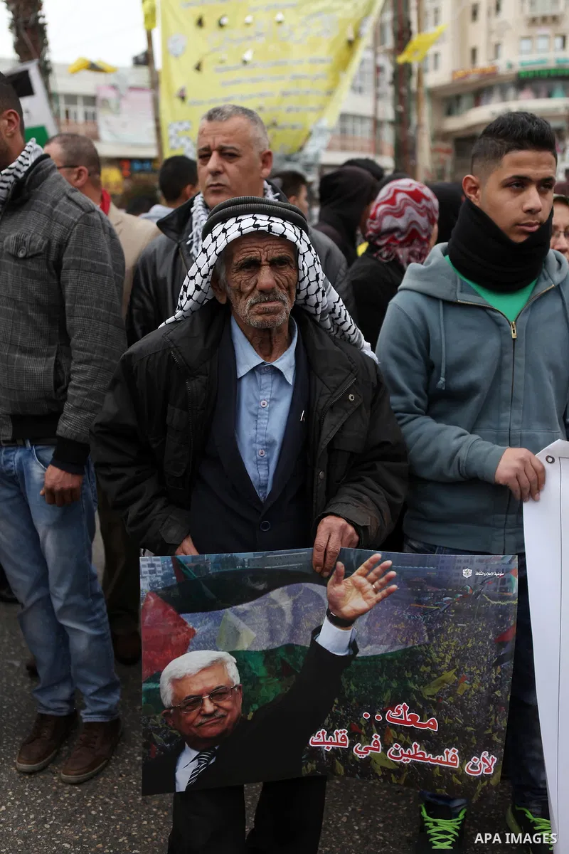 Palestinians hold placards during a rally organised by Fatah movement to support President Mahmoud Abbas' policy and calling to boycott Israeli goods, in the West Bank city of Ramallah, January 26, 2015. Photo by Shadi H...