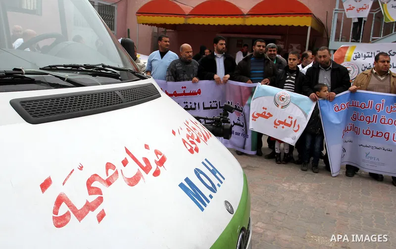 Palestinian doctors and workers of the health sector hold placards during a protest calling the government for pay their salaries, at Nasser hospital in Khan Younis in the southern Gaza Strip on January 26, 2015. Photo b...