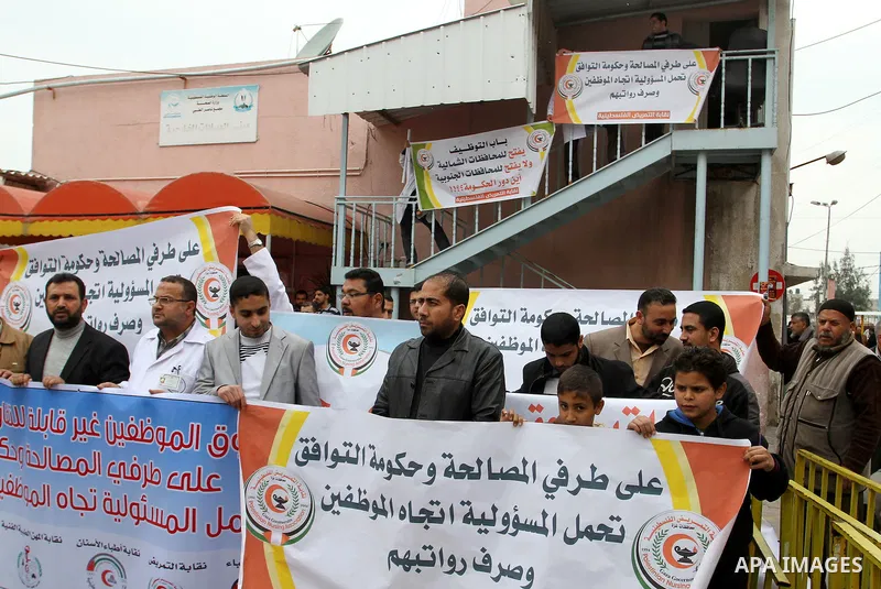 Palestinian doctors and workers of the health sector hold placards during a protest calling the government for pay their salaries, at Nasser hospital in Khan Younis in the southern Gaza Strip on January 26, 2015. Photo b...