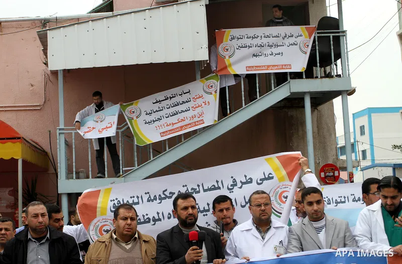 Palestinian doctors and workers of the health sector hold placards during a protest calling the government for pay their salaries, at Nasser hospital in Khan Younis in the southern Gaza Strip on January 26, 2015. Photo b...
