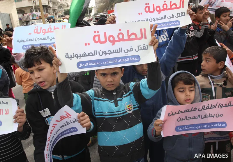 Palestinian children hold banners during a protest to show solidarity with the child prisoners in Israeli jails, in Gaza city, on January 27, 2015. Photo by Mohammed Asad