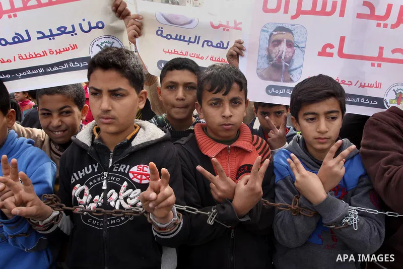 Palestinian children hold banners during a protest to show solidarity with the child prisoners in Israeli jails, in Gaza city, on January 27, 2015. Photo by Mohammed Asad