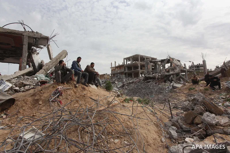 Palestinians sit on the rubbles of houses, which were destroyed during the recent Israeli offensive on Gaza Strip, in the last day of 2014, in Shijaiyah neighborhood, east Gaza city on January 27, 2015. The main U.N. aid...